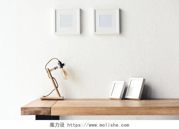 空白照片相框挂在墙上的工作场所与台灯